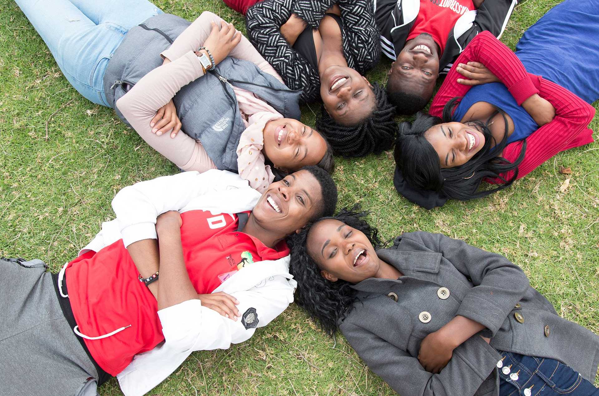 Group of young people lying on the ground smiling